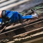 Roofer using a hammer during roof repair