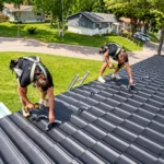 Roofers performing roof repair work on asphalt shingles